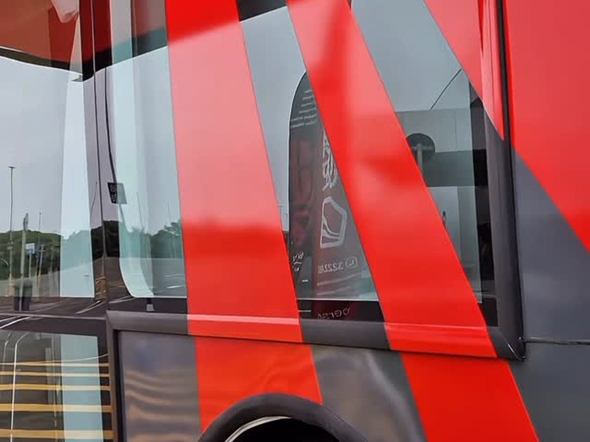 Ônibus com envelopamento completo em vinil vermelho e preto