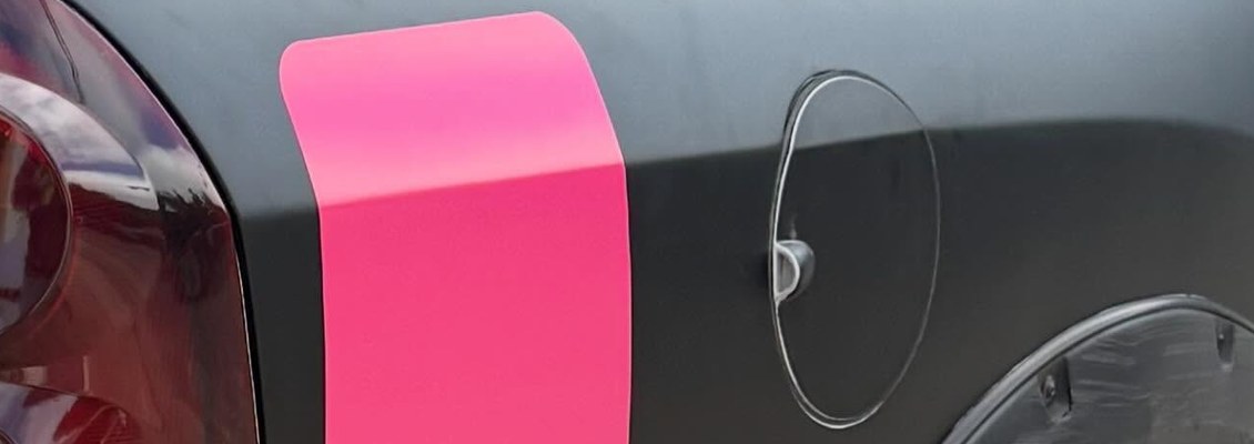 Detalhe de recorte de vinil rosa aplicado sobre lataria preta